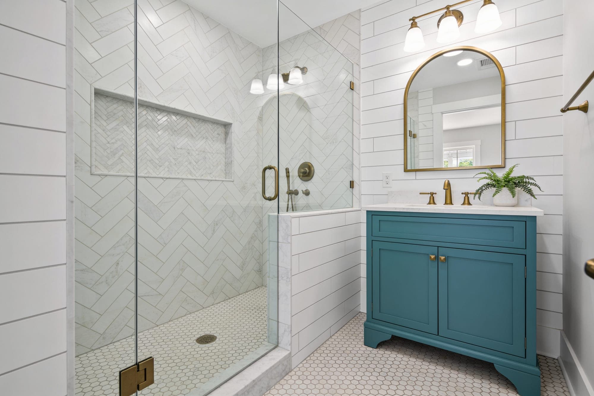Remodeled guest bathroom with herringbone shower niche and hexagon mosaic floor