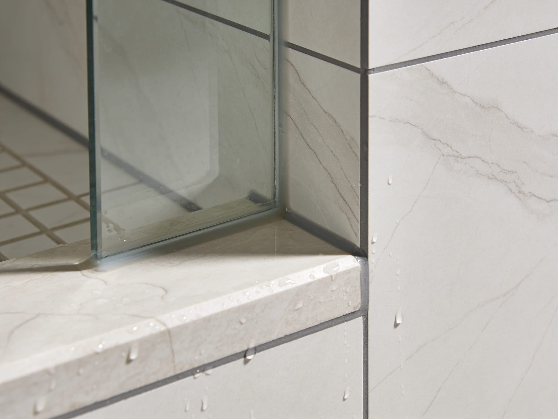 Close-up of a precisely mitred porcelain corner on a shower curb