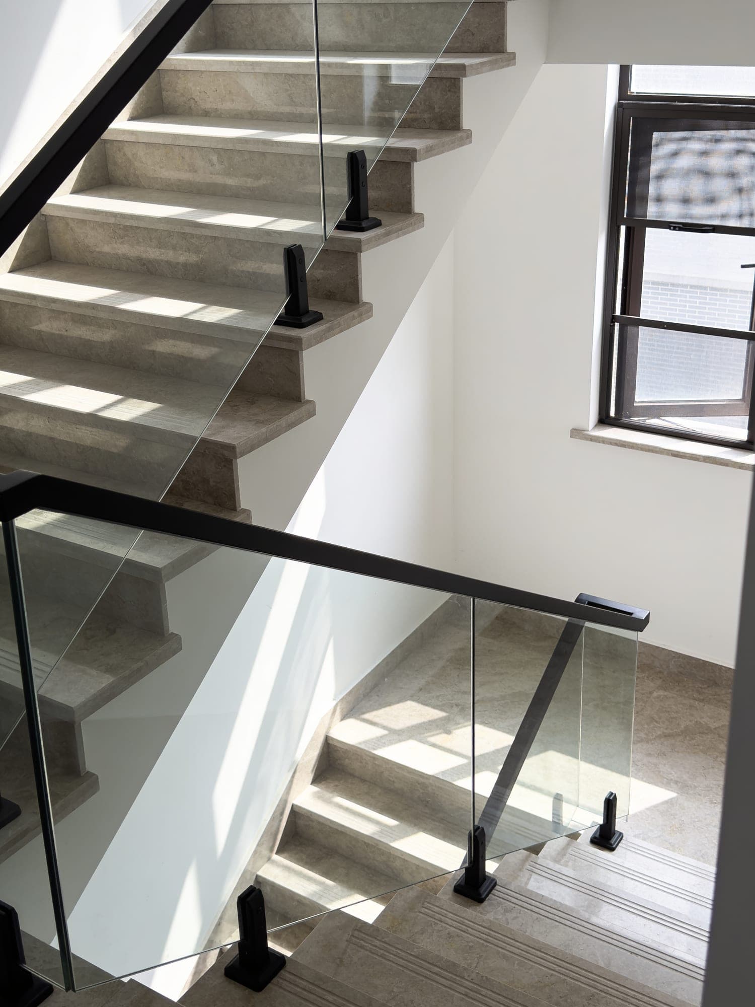 Staircase finished with large-format porcelain treads and mitred risers